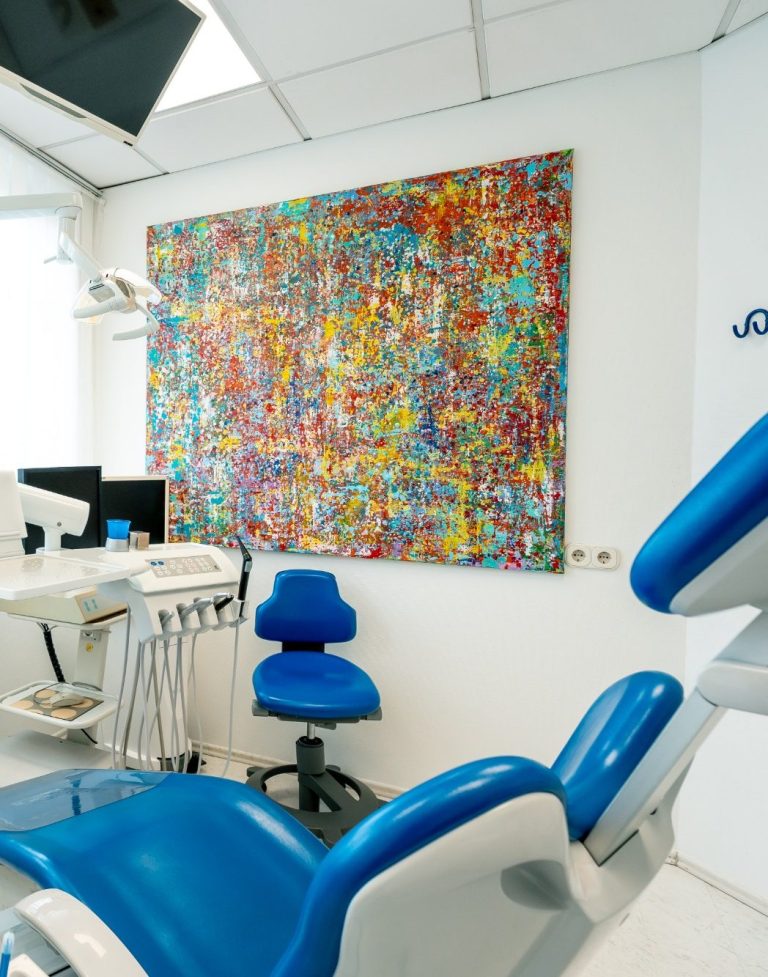 Praxis Dr. med. dent. Michael Fuchs Buntes Kunstwerk an der Wand in einer modernen Zahnarztpraxis.